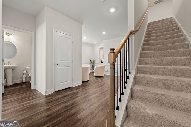 stairway featuring wood finished floors, recessed lighting, and baseboards