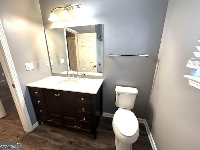 4254 Wood Cove Dr, Snellville, GA 30039 - half bathroom featuring vanity, baseboards, toilet, and wood finished floors