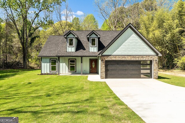 view of front of property with board and batten siding, a garage, a front lawn, a shingled roof, and concrete driveway
