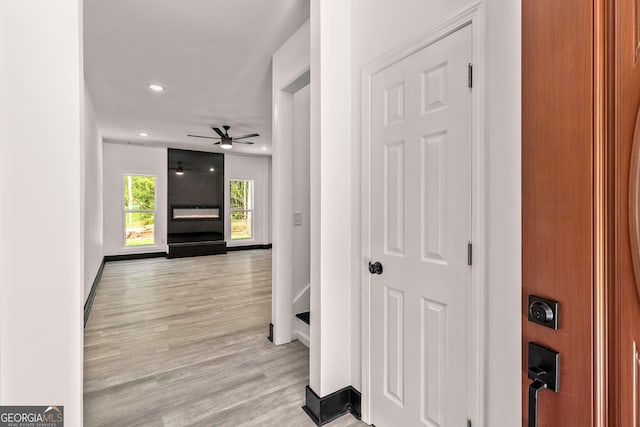 hall featuring recessed lighting, light wood finished floors, and baseboards