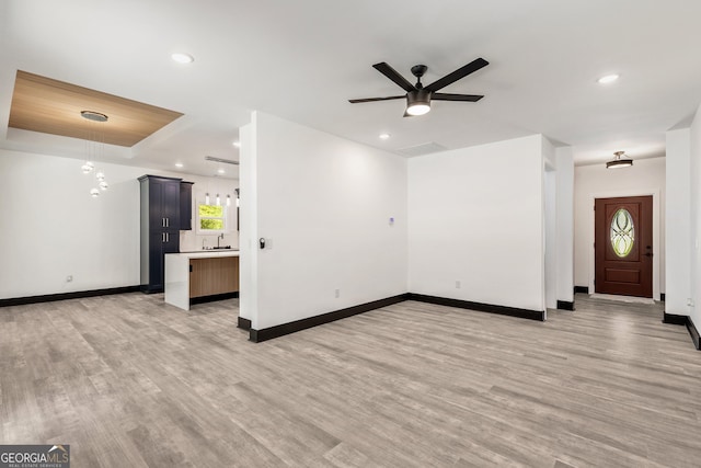 unfurnished living room featuring baseboards, a sink, a ceiling fan, light wood finished floors, and recessed lighting