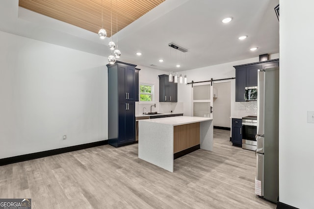 kitchen with light countertops, backsplash, visible vents, stainless steel appliances, and a sink