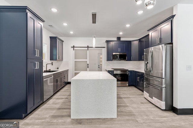 kitchen with recessed lighting, light wood-type flooring, a center island, and appliances with stainless steel finishes
