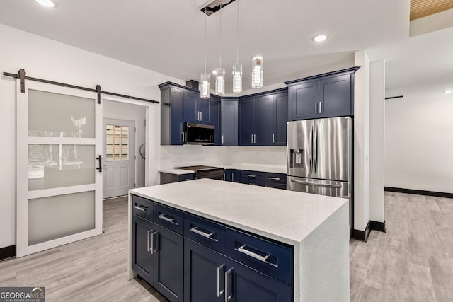 kitchen with stainless steel appliances, a barn door, light wood-type flooring, and blue cabinetry
