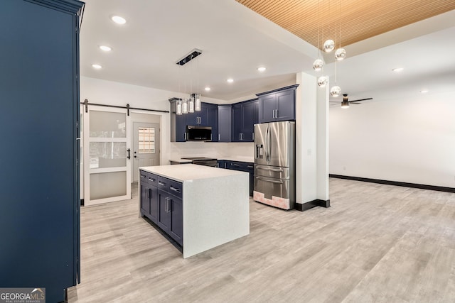 kitchen featuring a barn door, light countertops, light wood finished floors, recessed lighting, and stainless steel appliances