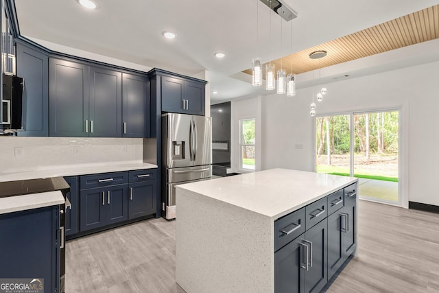 kitchen with light wood-style flooring, decorative light fixtures, stainless steel fridge, and recessed lighting