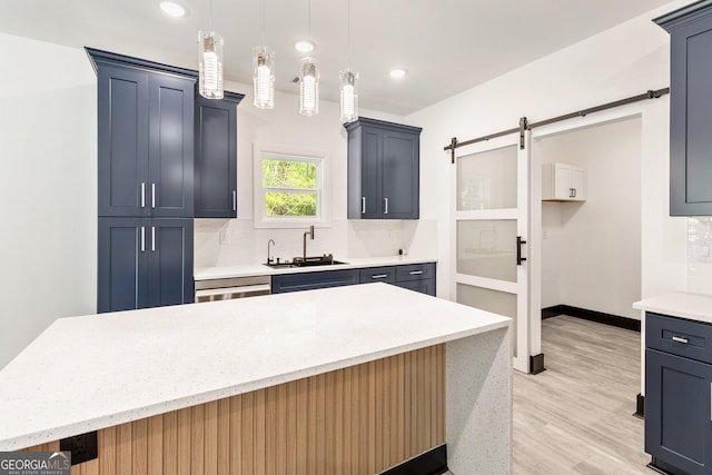 kitchen with light stone countertops, decorative light fixtures, light wood-style floors, decorative backsplash, and a sink