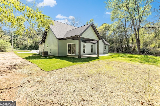 view of property exterior featuring a patio, a yard, cooling unit, and a shingled roof