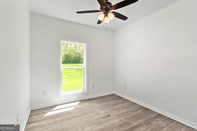 unfurnished room with wood finished floors, baseboards, and a ceiling fan
