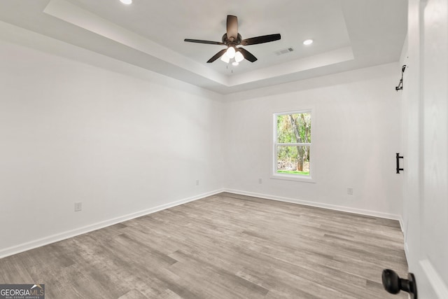 empty room featuring baseboards, recessed lighting, a raised ceiling, visible vents, and ceiling fan