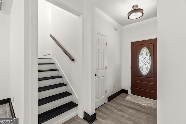entrance foyer featuring stairs, baseboards, and wood finished floors