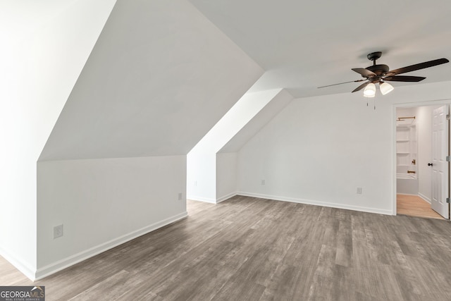 bonus room featuring wood finished floors, baseboards, a ceiling fan, and lofted ceiling