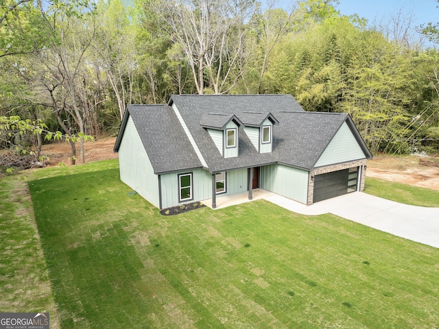 view of front facade featuring a garage, roof with shingles, a front lawn, and concrete driveway
