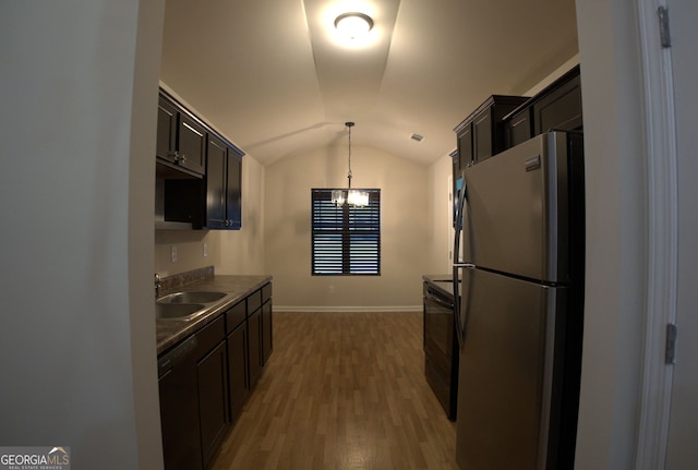 kitchen with vaulted ceiling, a chandelier, freestanding refrigerator, dark countertops, and dishwasher