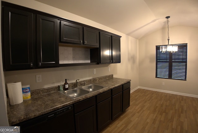 kitchen featuring black dishwasher, dark countertops, light wood-style floors, lofted ceiling, and a sink