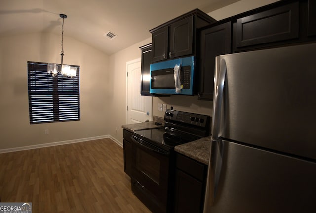 kitchen featuring visible vents, freestanding refrigerator, black electric range oven, a chandelier, and vaulted ceiling