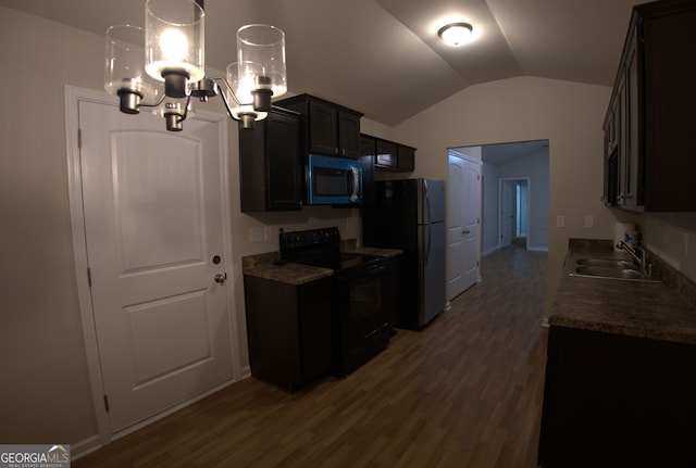 kitchen featuring freestanding refrigerator, dark wood-style flooring, stainless steel microwave, a sink, and black range with electric stovetop