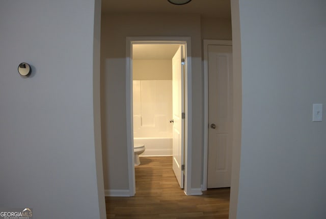 hall with baseboards and wood finished floors