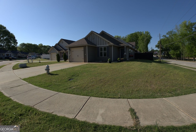 view of front of property featuring a front yard, driveway, board and batten siding, and an attached garage
