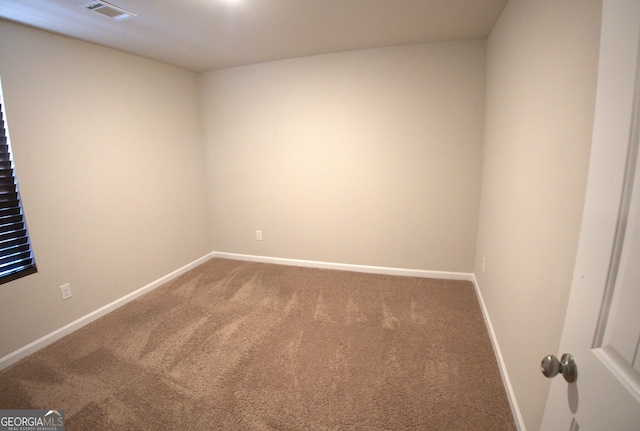 carpeted spare room featuring baseboards and visible vents