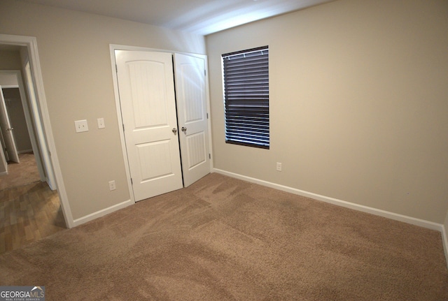 unfurnished bedroom featuring a closet, carpet, and baseboards