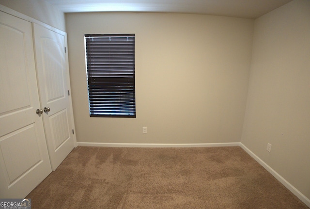 unfurnished bedroom featuring a closet, carpet flooring, and baseboards