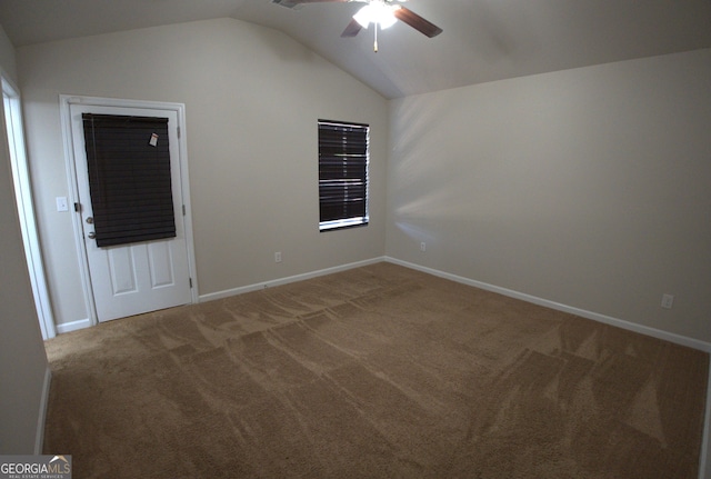 empty room featuring baseboards, carpet floors, vaulted ceiling, and ceiling fan