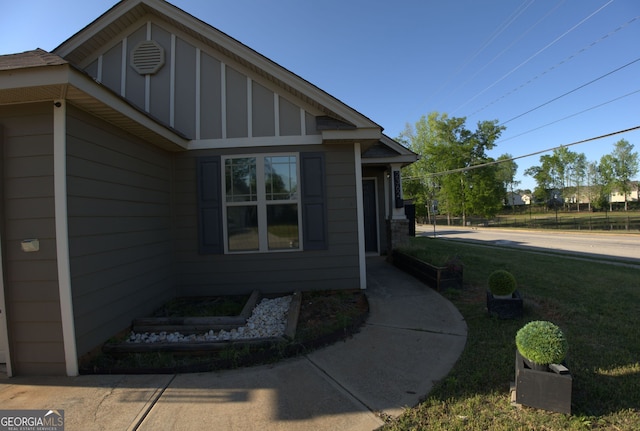 view of side of home with board and batten siding and a lawn