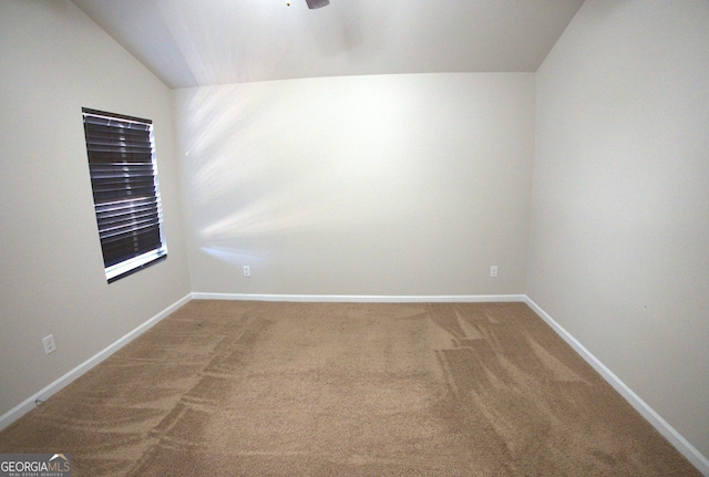 empty room featuring baseboards, a ceiling fan, carpet flooring, and vaulted ceiling