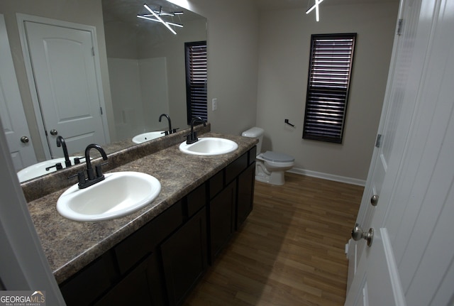 bathroom with a sink, toilet, and wood finished floors