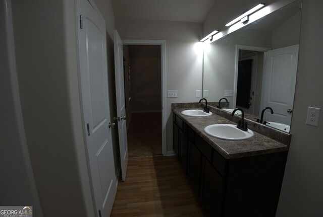 bathroom featuring double vanity, a sink, and wood finished floors