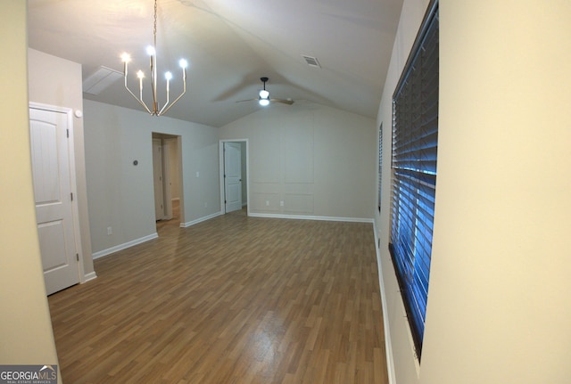 interior space with visible vents, baseboards, vaulted ceiling, and wood finished floors