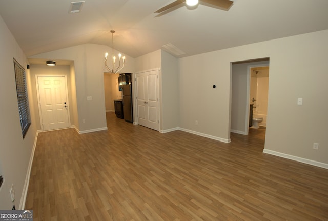 interior space featuring wood finished floors, ceiling fan with notable chandelier, lofted ceiling, and visible vents