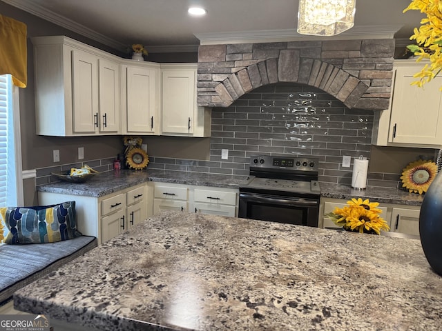 kitchen featuring tasteful backsplash, dark stone countertops, stainless steel range with electric stovetop, crown molding, and white cabinetry