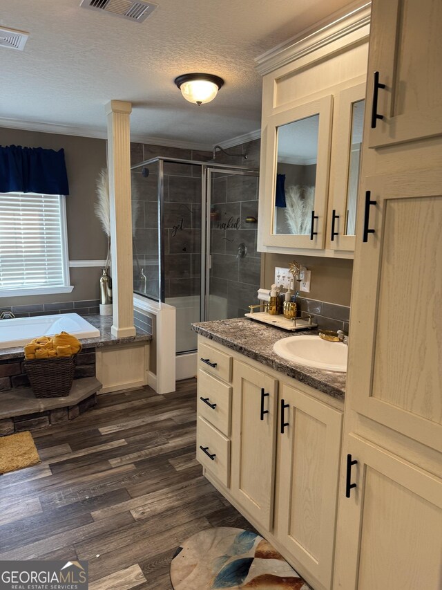 bathroom featuring a bath, a textured ceiling, vanity, wood finished floors, and a stall shower