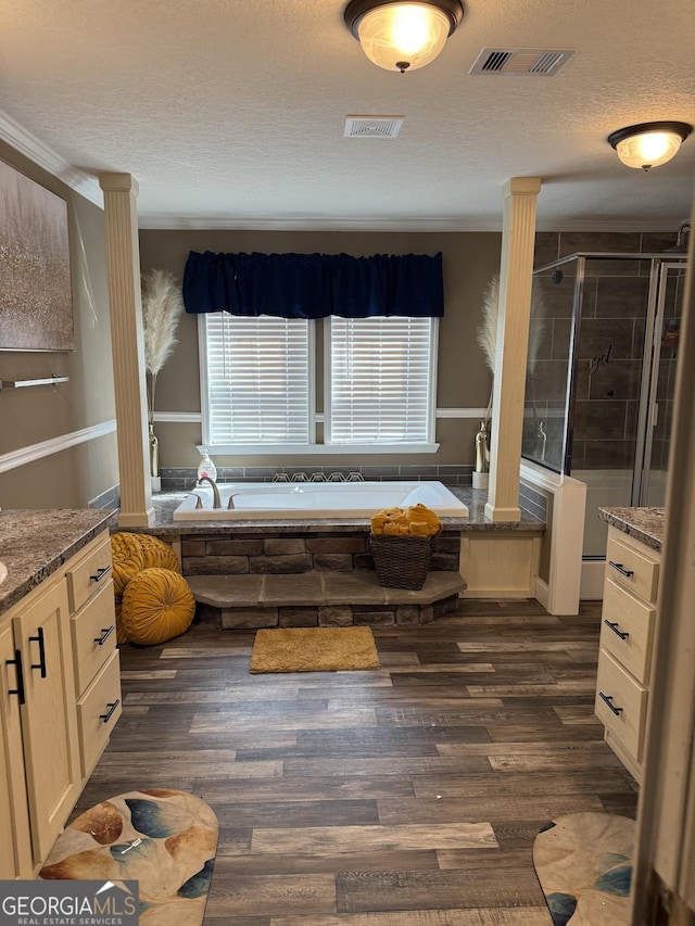 full bath featuring visible vents, a shower stall, ornate columns, and wood finished floors
