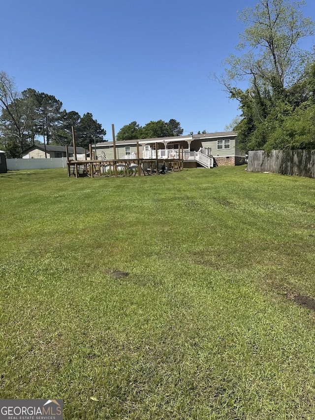 view of yard featuring a wooden deck and fence