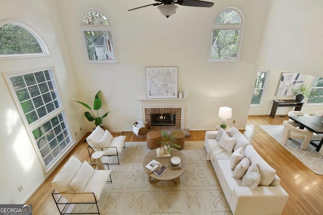 3711 Spinnaker Cir, Alpharetta, GA 30005 - living area with a towering ceiling, ceiling fan, wood finished floors, a fireplace, and baseboards