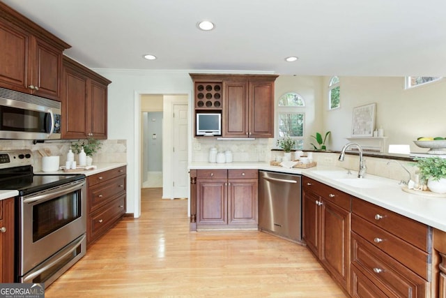 3711 Spinnaker Cir, Alpharetta, GA 30005 - kitchen with appliances with stainless steel finishes, a sink, light wood finished floors, tasteful backsplash, and ornamental molding