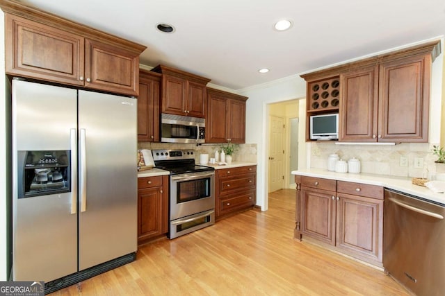 3711 Spinnaker Cir, Alpharetta, GA 30005 - kitchen featuring appliances with stainless steel finishes, tasteful backsplash, light wood-type flooring, crown molding, and light countertops