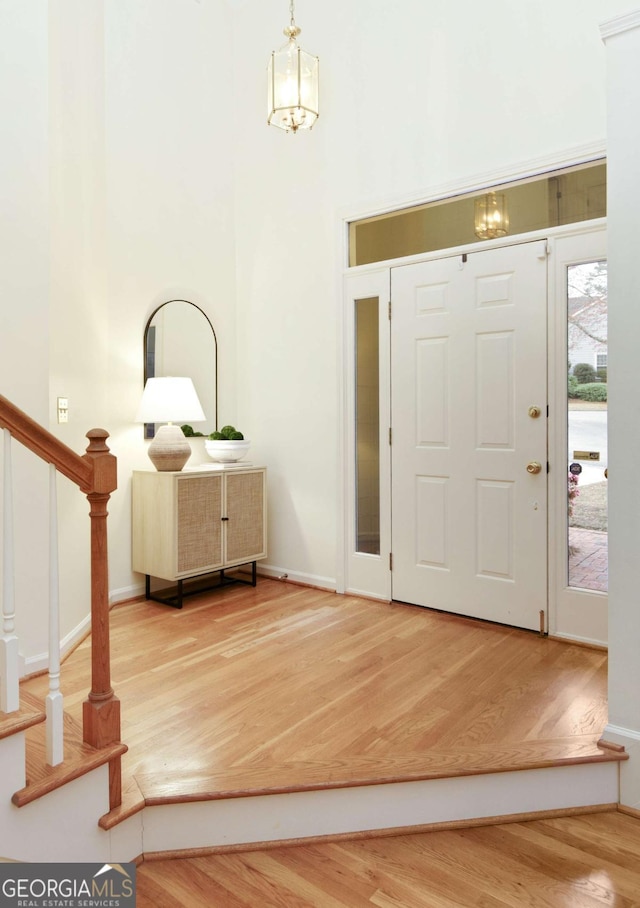 3711 Spinnaker Cir, Alpharetta, GA 30005 - foyer entrance with wood finished floors, a high ceiling, stairs, and baseboards