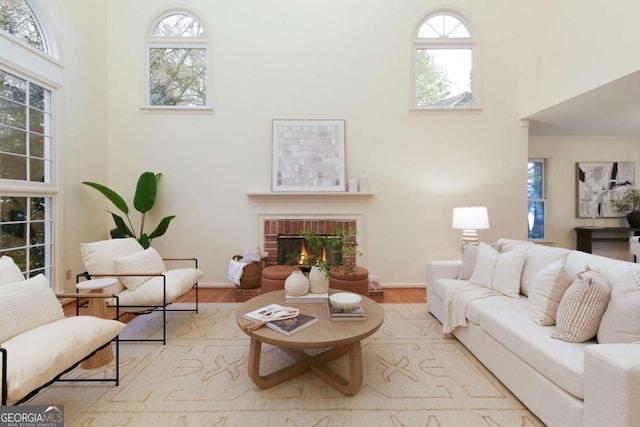 3711 Spinnaker Cir, Alpharetta, GA 30005 - living area featuring a towering ceiling, a fireplace, healthy amount of natural light, wood finished floors, and baseboards