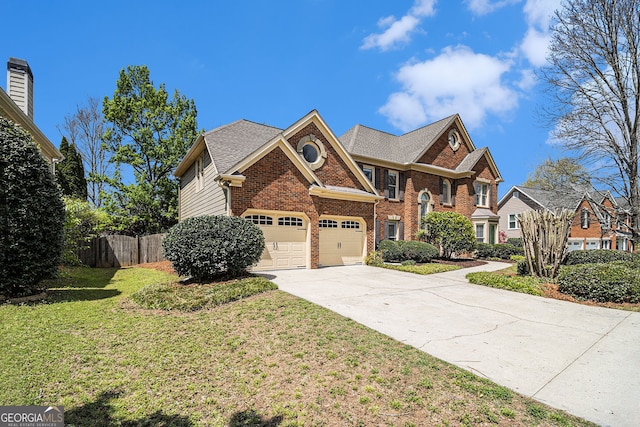 view of front facade featuring brick siding, a front lawn, driveway, and fence
