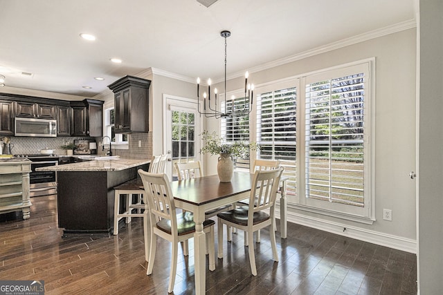 dining room with an inviting chandelier, a healthy amount of sunlight, and crown molding