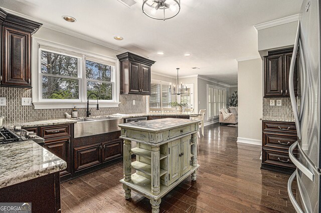 kitchen with freestanding refrigerator, dark brown cabinetry, and tasteful backsplash