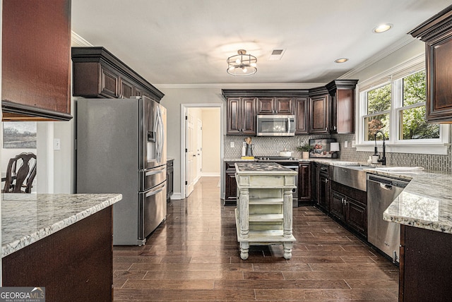 kitchen featuring crown molding, a sink, dark brown cabinetry, stainless steel appliances, and visible vents