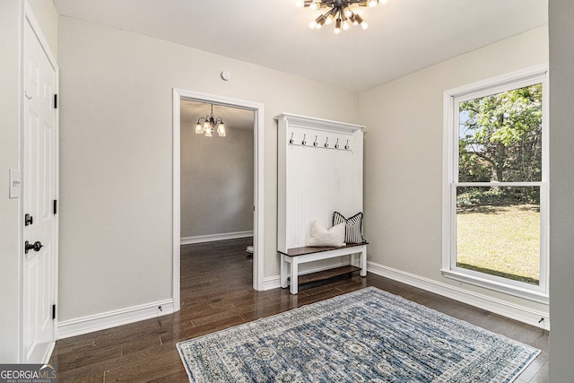 entrance foyer with baseboards, wood finished floors, and a chandelier
