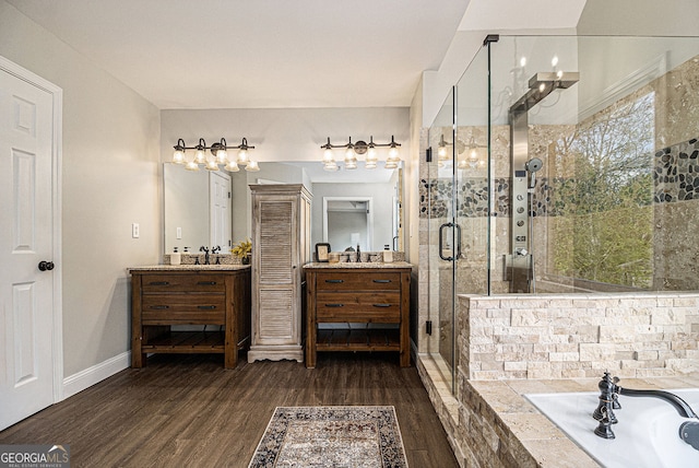 bathroom with a garden tub, wood finished floors, vanity, and a shower stall