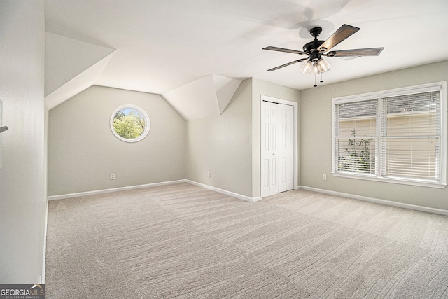 additional living space featuring carpet, lofted ceiling, baseboards, and a ceiling fan