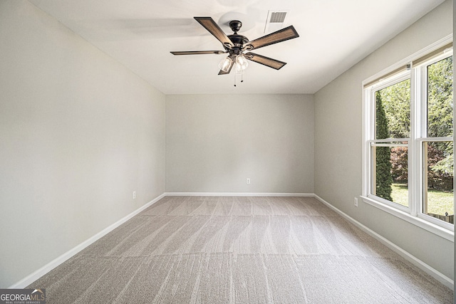 empty room with light carpet, baseboards, visible vents, and ceiling fan